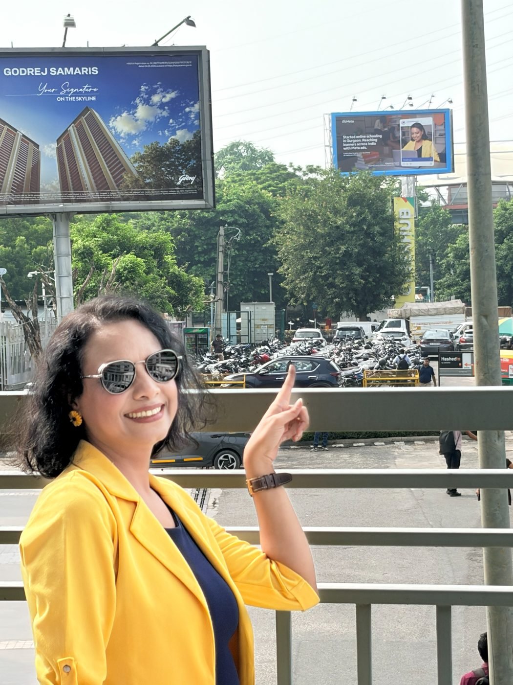 Vijayshree Kalani pointing at her Meta billboard in Gurugram